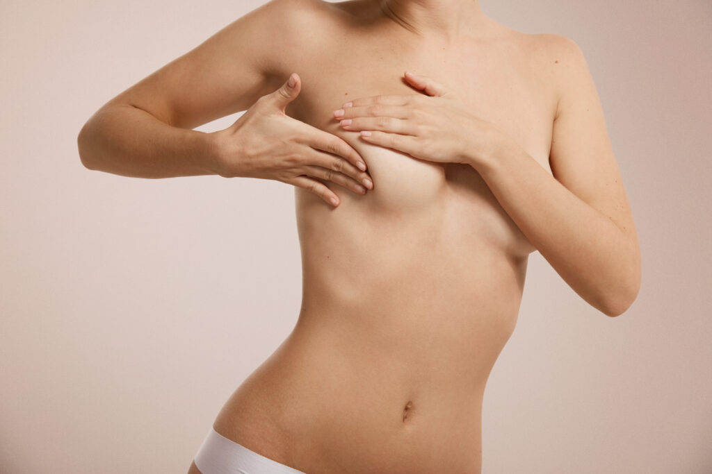 Woman checking her breast| Featured image for What is Micromastia? Blog